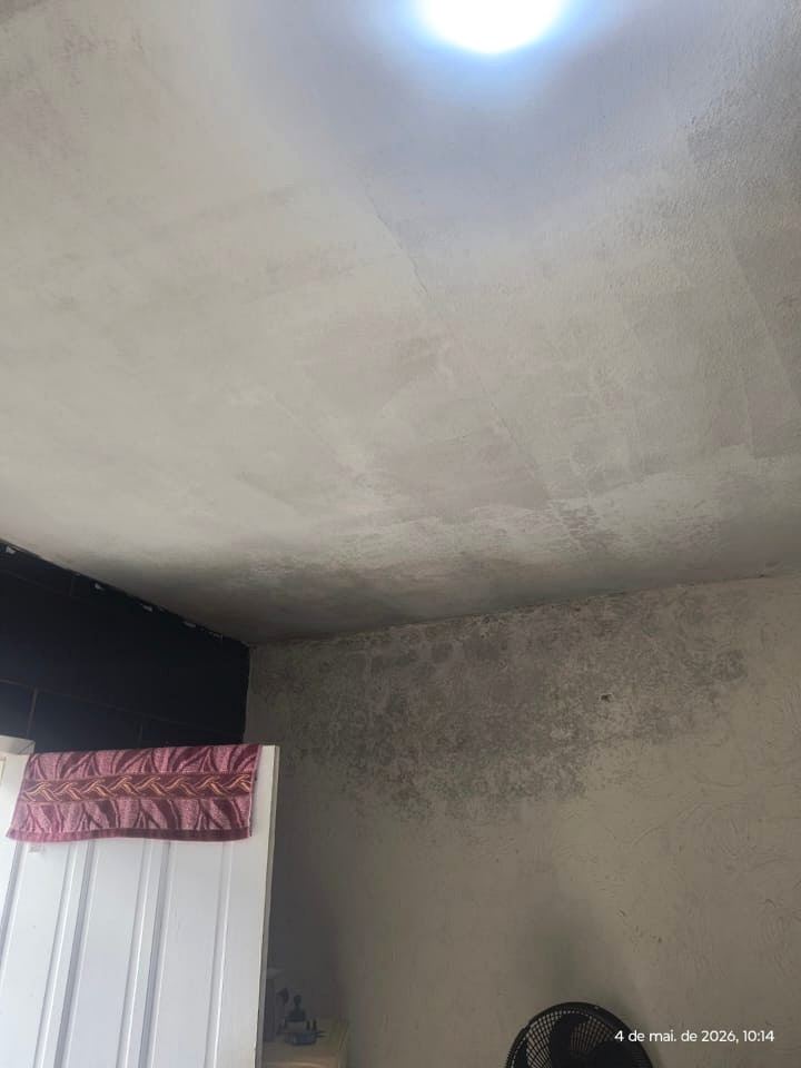 Teto com manchas de umidade e descolamento de pintura junto ao encontro com a parede.